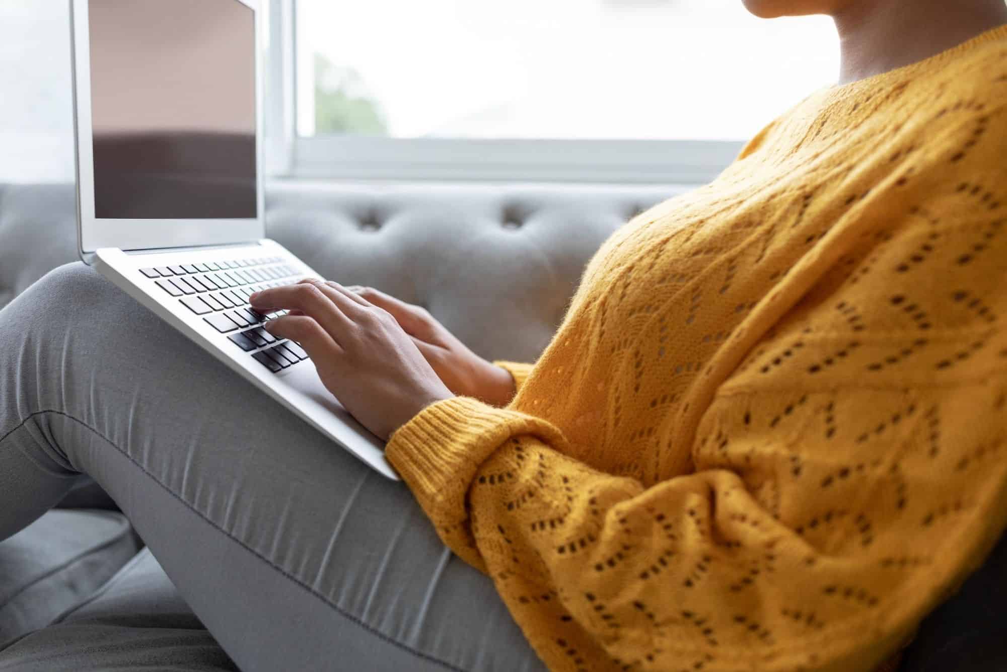 ethnic woman on couch with laptop